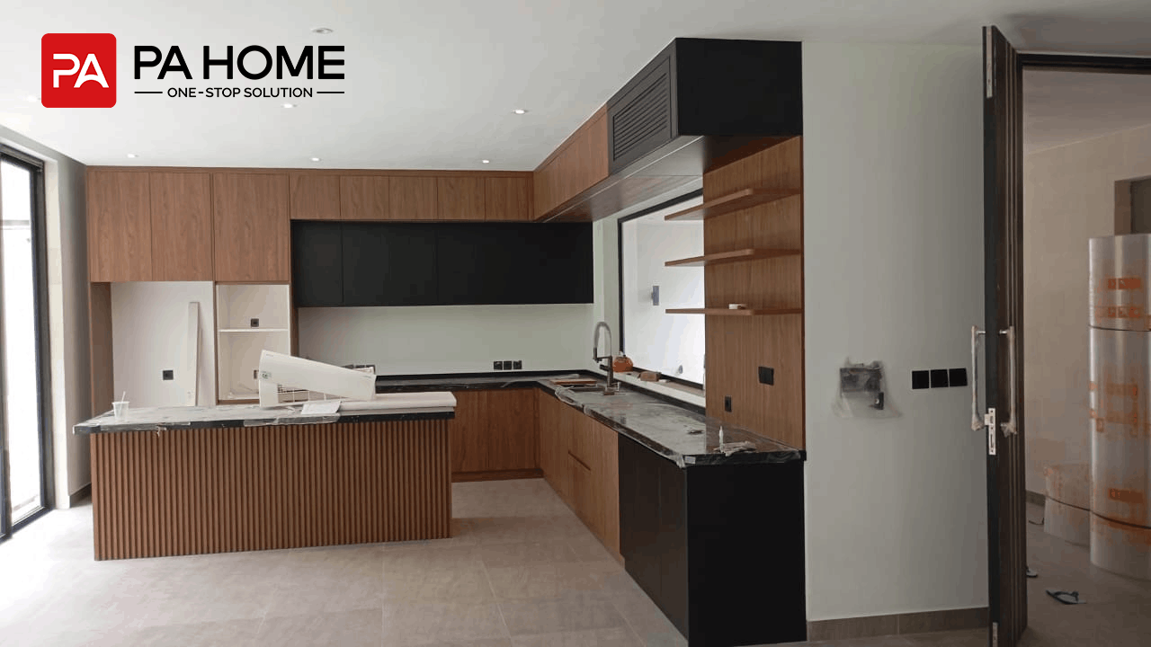 Vila 4 Kamar Tidur di Bali dengan Lemari dan Furnitur Built-In Sesuai Pesanan 5 Kabinet dapur kustom bernuansa kayu dengan kabinet atas berwarna hitam, meja island berlekuk, dan rak terbuka dalam proyek vila di Bali.