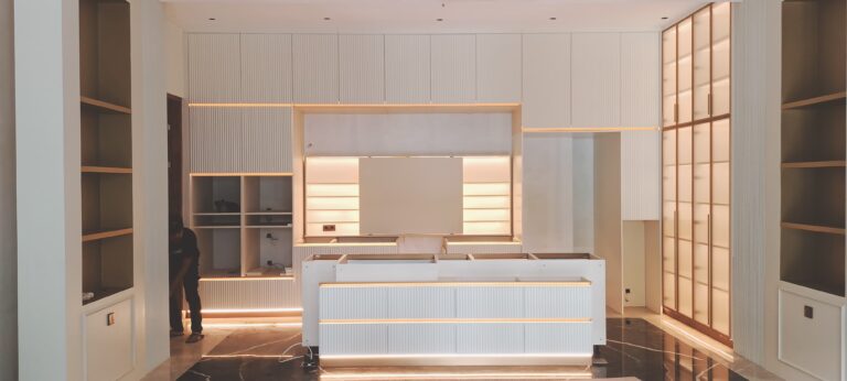 The custom floating white cabinets in this project have no frames or door handles, featuring raised vertical stripes and LED edge lighting, creating a sleek and modern aesthetic.