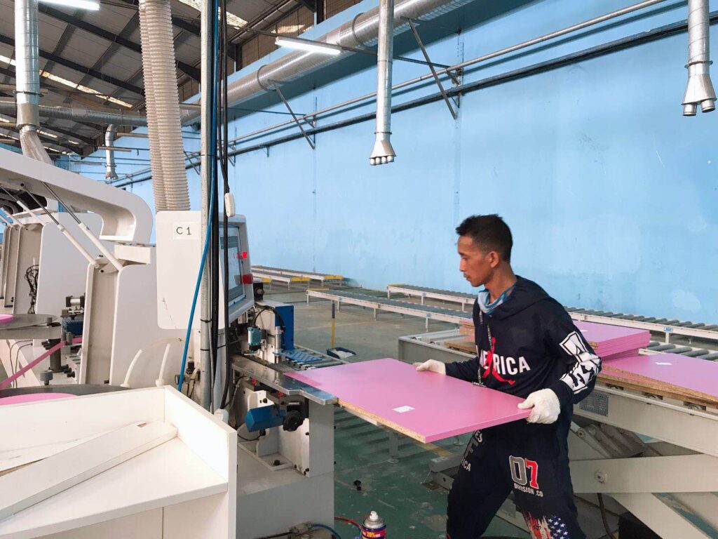 In the workshop of PA home Indonesia cabinet factory, workers will send the cut sheets to the machine for further processing