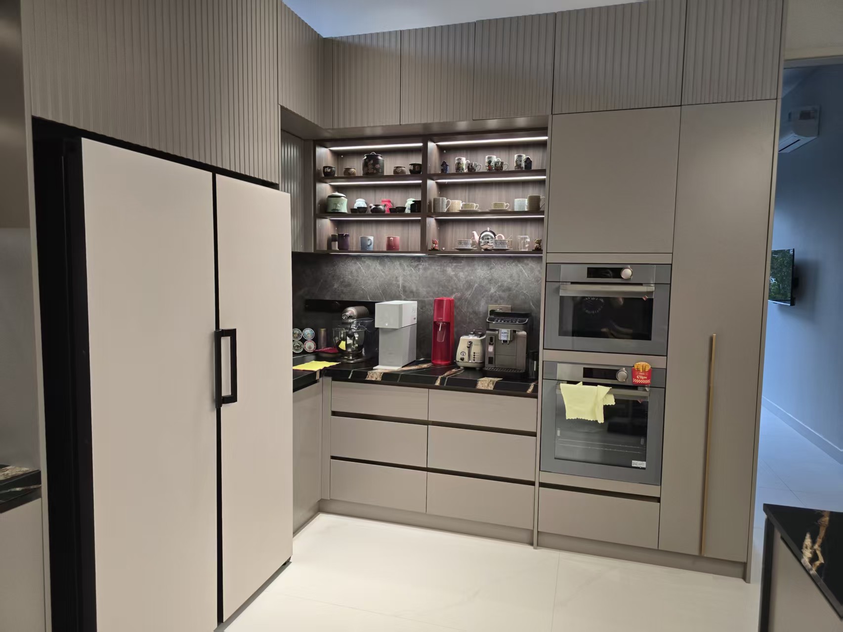 Corner kitchen cabinets with built-in ovens, refrigerator compartment, and under-shelf lighting