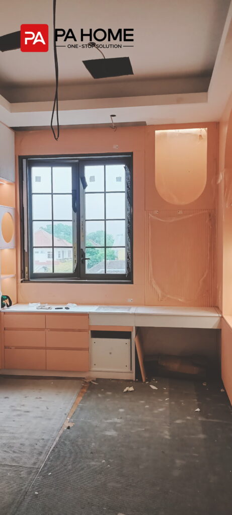 Renovasi Rumah di Indonesia dengan Kabinet Dapur dan Lemari Pakaian Kamar Tidur yang Dibuat Sesuai Pesanan 6 Kamar anak-anak yang dirancang khusus dengan meja belajar terintegrasi, lemari berwarna pastel, laci, dan penyimpanan di sisi jendela di Indonesia.