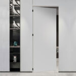 A minimalist white flush door with a seamless design, offering a sleek and modern look. Perfect for those seeking high-quality wholesale interior doors.
