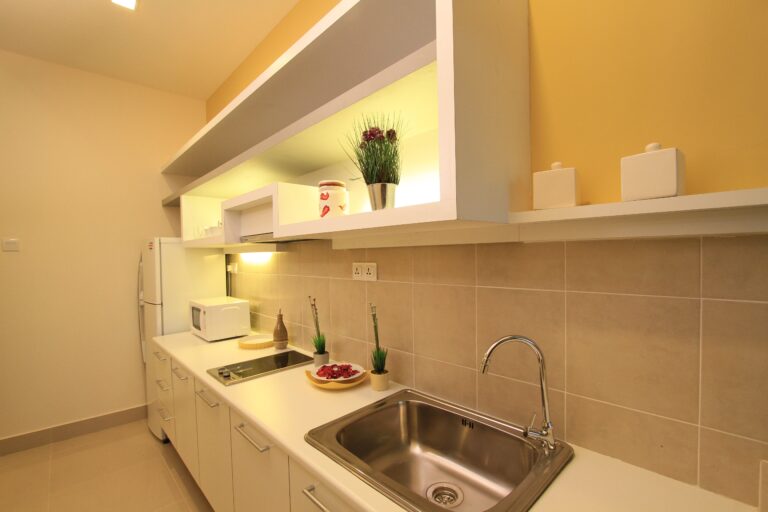 Contemporary kitchen design in Malaysia Kuala Lumpur hotel with clean white kitchen cabinets.