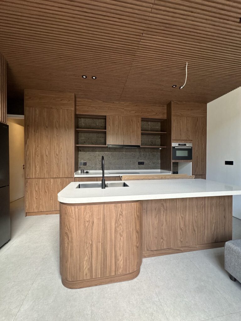 Umalas Creek Villa Custom Cabinets Project wood veneer kitchen island with black matte faucet