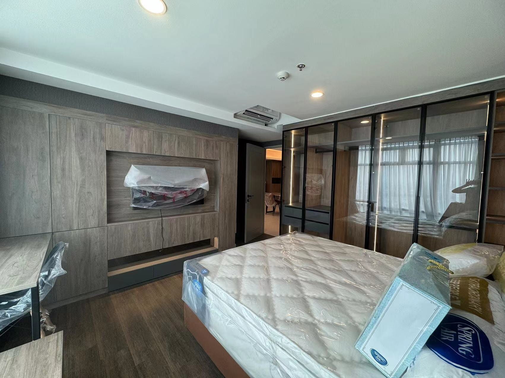 Medan Manhattan Apartment Renovation in Indonesia 6 Medan apartment renovation bedroom with glass wardrobe, TV cabinet, and custom desk area.