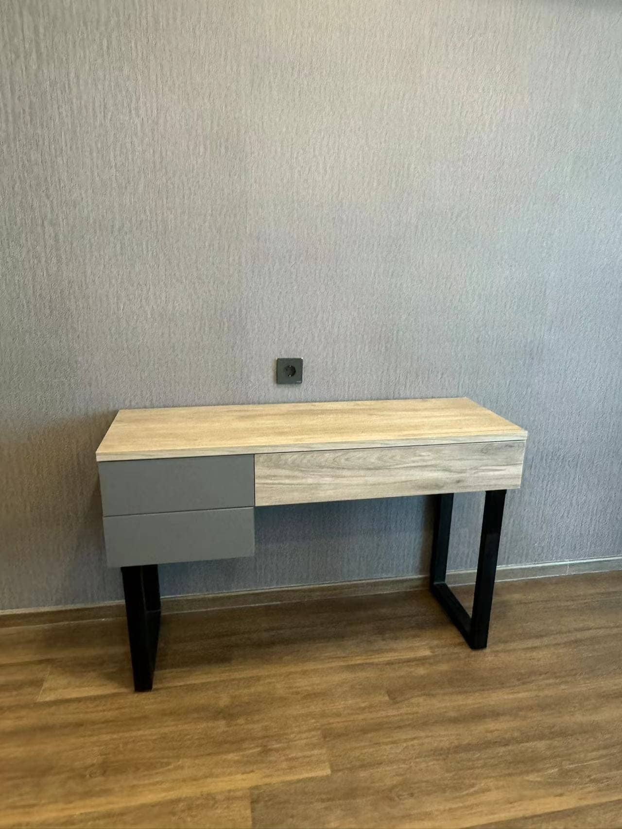 Medan Manhattan Apartment Renovation in Indonesia 15 Compact desk and drawer cabinet with wood top, grey drawers, and black metal legs.