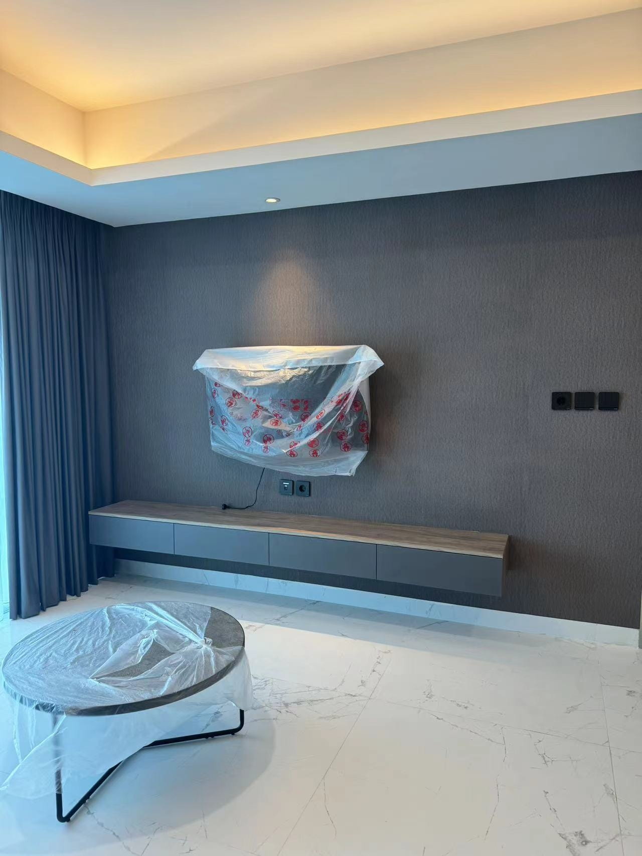 Medan Manhattan Apartment Renovation in Indonesia 7 Modern living room with floating TV cabinet and textured feature wall in Medan apartment.