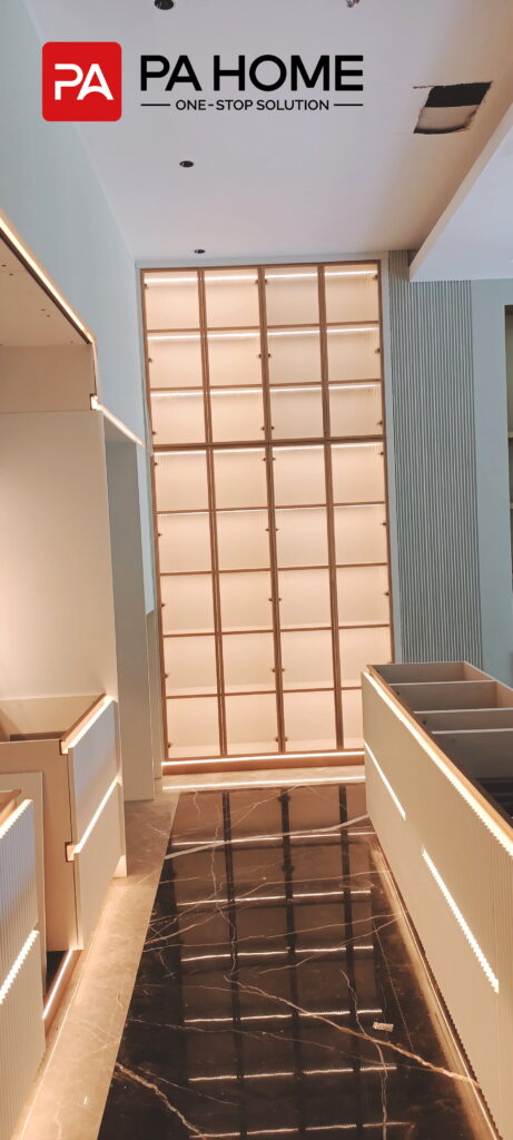 Renovasi Rumah di Indonesia dengan Kabinet Dapur dan Lemari Pakaian Kamar Tidur yang Dibuat Sesuai Pesanan 1 Lemari pajangan bercahaya dari lantai hingga langit-langit dengan lemari dapur khusus dan pencahayaan di area tengah dapur.