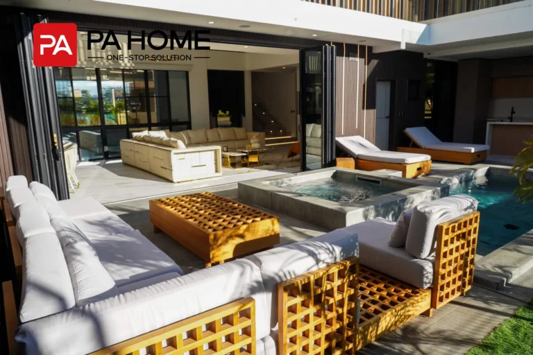 Luxury villa poolside terrace with outdoor seating and large sliding glass doors in Costa Rica