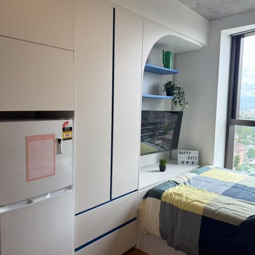 Custom nightstand with a minimalist design in a student apartment in Sydney, featuring storage compartments.