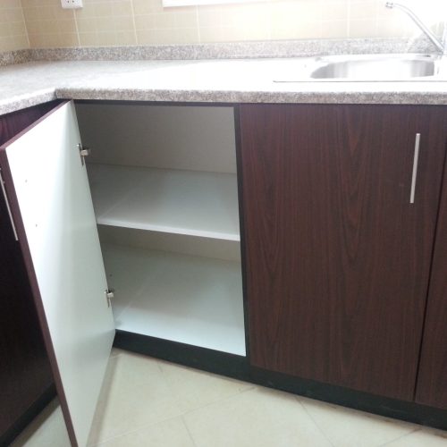 Kitchen cabinets with a cherry wood veneer and silver metal handles, combining warmth and sophistication in the design.