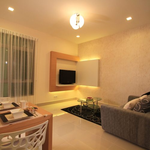 Modern hotel living room in Malaysia with minimalist furniture and TV unit.