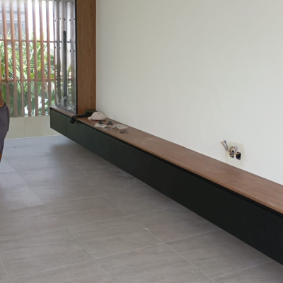 low profile floating black storage console cabinet with walnut top lining living room wall