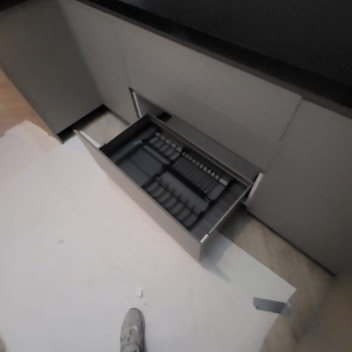 Under-counter utensil drawer with integrated dish rack in matte-gray Dutch kitchen cabinet