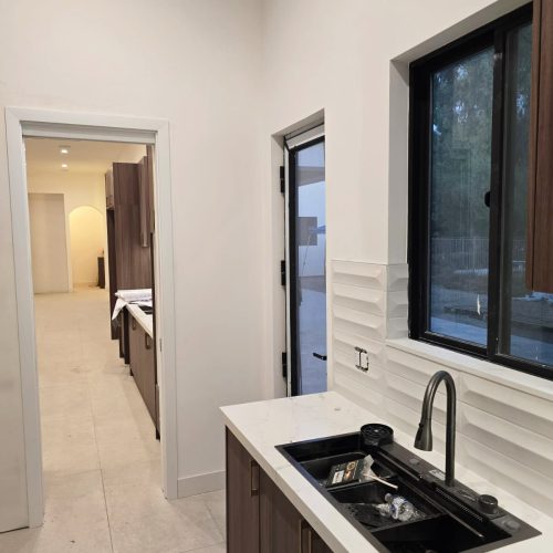 Custom kitchen with dark wood cabinetry and marble countertop.