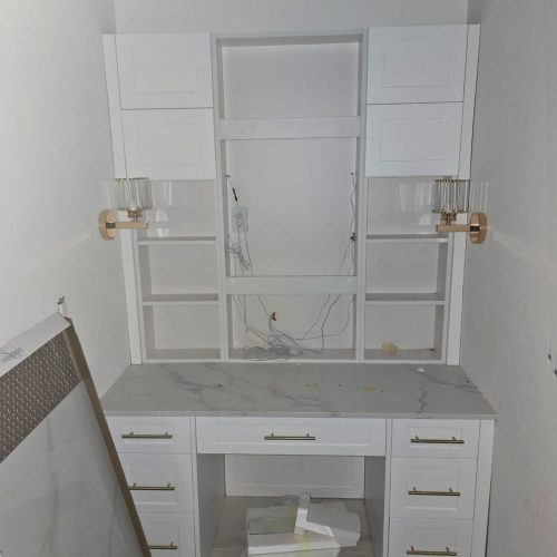 Full House Custom In America white vanity with marble countertop and brass fixtures in a modern design.