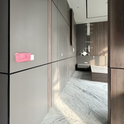 Modern mirrored custom cabinets in bedroom with elegant wood and black accents.