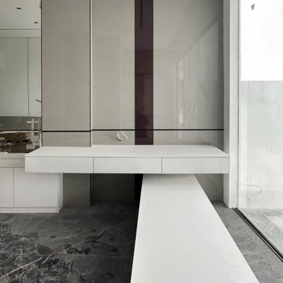 Custom mirrored cabinets and minimalist shelving in an upscale bedroom with clean lines and contemporary design.