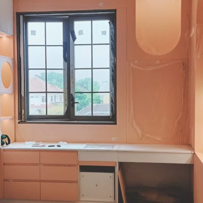 This Indonesia full house custom project features pink walls and a pink-and-white two-tone desk with built-in cabinets, creating a stylish and functional workspace.