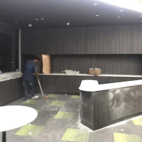 office bar cabinet installation with dark wood veneer and white stone countertops in Indonesian workspace