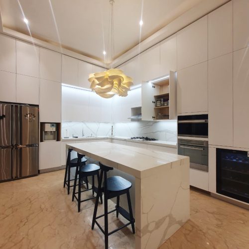 Modern Indonesian kitchen with custom kitchen cabinets, sleek white finishes, and stylish lighting.