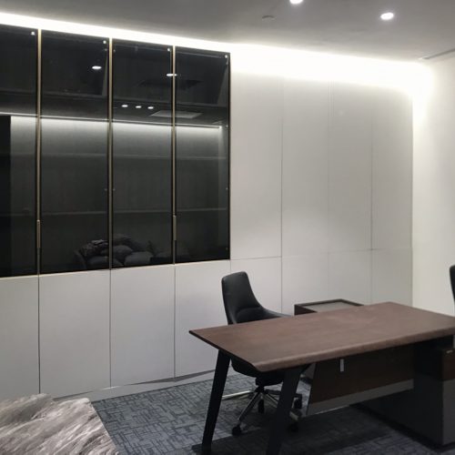 office cabinet with glass-front doors and LED shelf lighting in Indonesian corporate workspace