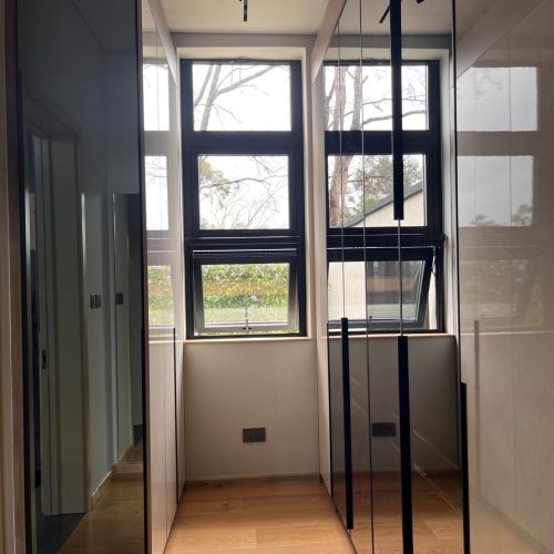 narrow wardrobe aisle with reflective doors