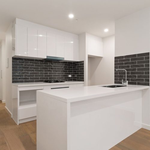 Melbourne Parkview Apartment Custom Cabinets Project modern kitchen with sleek white cabinetry and black subway tile backsplash