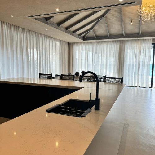 matte black faucet and undermount sink on kitchen island with dining backdrop