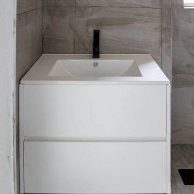 Custom bathroom vanity with sleek black faucet in Ongwe Apartment bathroom.