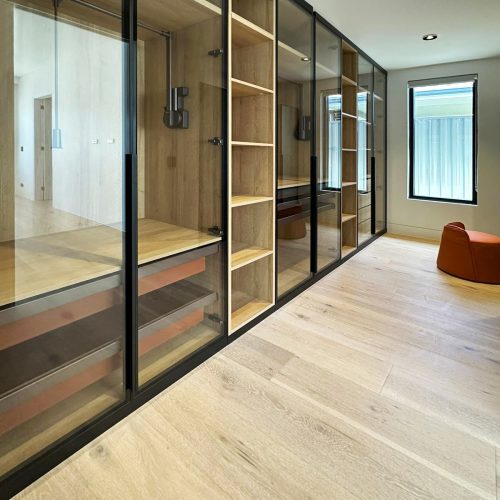Glass door wardrobe with oak interiors for custom cabinets in Sydney.
