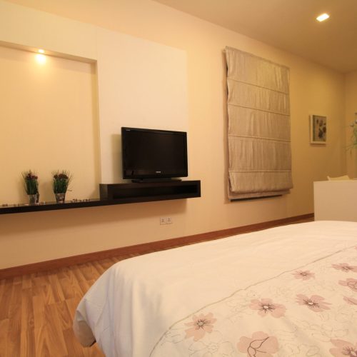 A modern TV cabinet with a feature background wall, designed for a hotel room.