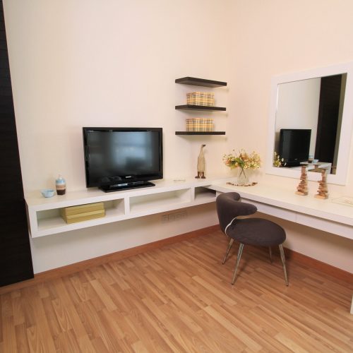 A modern TV cabinet in a hotel room, featuring clean lines and ample storage.