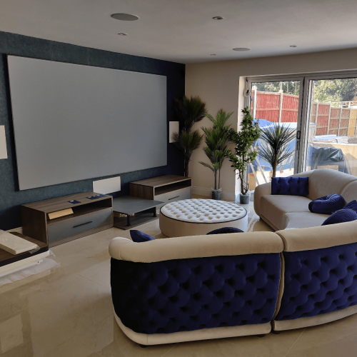 UK custom tv units beneath projection screen in curved sofa lounge