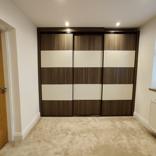sliding door wardrobe with checkerboard walnut and cream panels