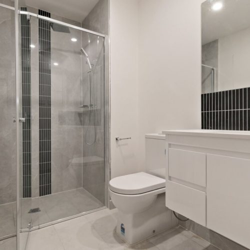 Melbourne Parkview Apartment Custom Cabinets Project modern bathroom with white vanity and black tile accent wall