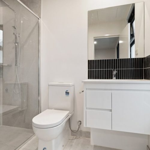 Parkview Apartment Custom Cabinets Project contemporary bathroom with white vanity and black tiled accent wall
