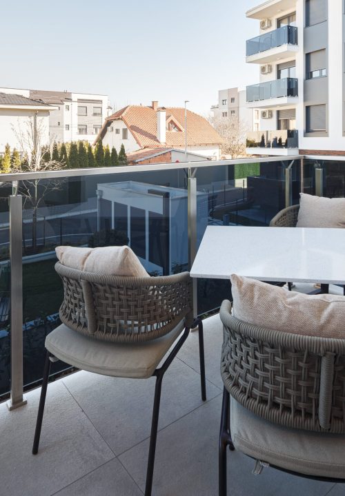 Zemun Stan Apartment Project in Serbia 2 Zemun stan apartment balcony with outdoor furniture and a scenic view of the neighborhood.