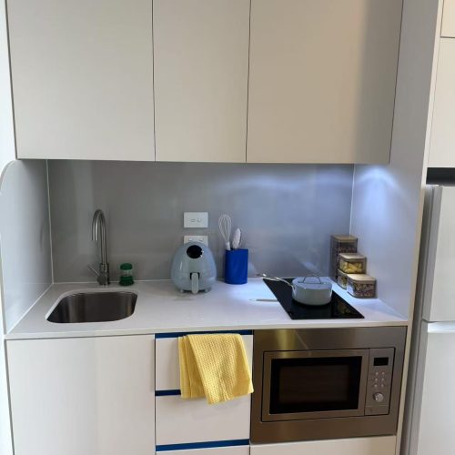 Custom kitchen cabinet in a Sydney student apartment with modern appliances.