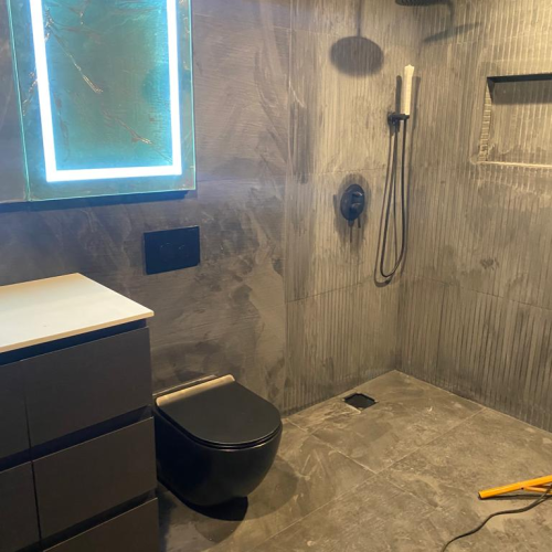 Custom cabinet in Los Angeles bathroom with modern design and backlit mirror.