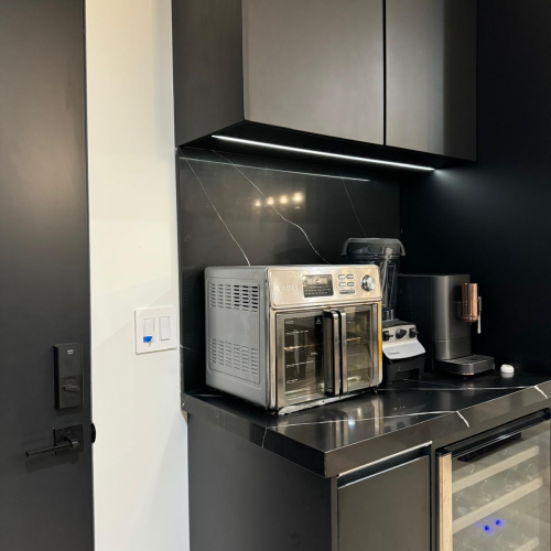 Custom cabinet in Los Angeles kitchen with modern black finish and countertop appliances.