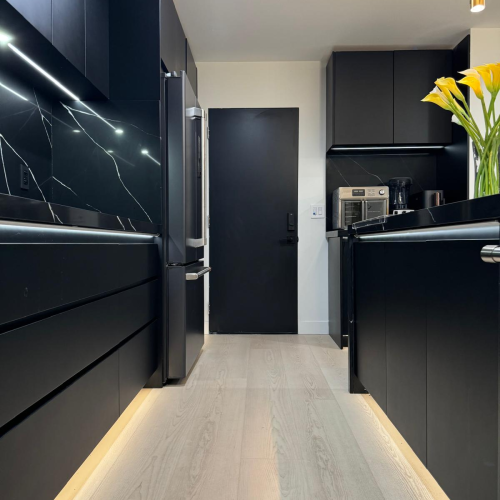 Custom cabinet in Los Angeles kitchen with dark cabinetry and modern lighting.