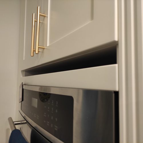 close-up of custom kitchen cabinet Canada with a built-in microwave and drawer storage