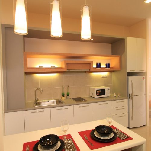 Stylish kitchen in a Malaysia Kuala Lumpur hotel with beige and white kitchen cabinetry.
