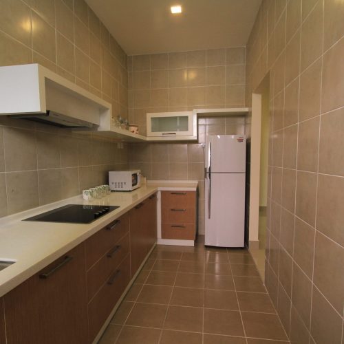 Modern kitchen in a Malaysia Kuala Lumpur hotel with white and beige kitchen cabinets.