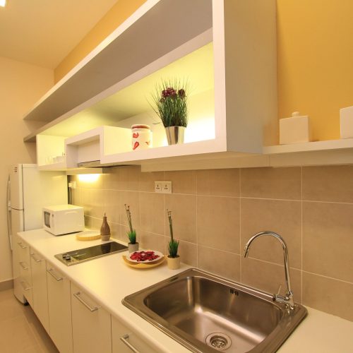 Contemporary kitchen design in Malaysia Kuala Lumpur hotel with clean white kitchen cabinets.