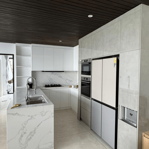 White kitchen island and kitchen cabinets in a Bali home renovation.