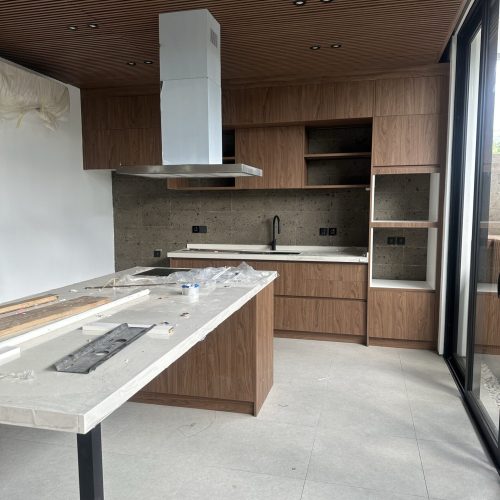 Umalas Creek Villa Custom Cabinets Project floor to ceiling wood veneer wall cabinets with stainless steel range hood