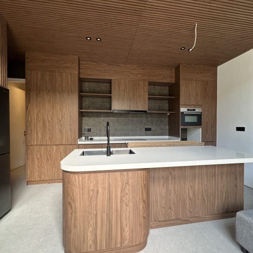 Umalas Creek Villa Custom Cabinets Project wood veneer kitchen island with black matte faucet