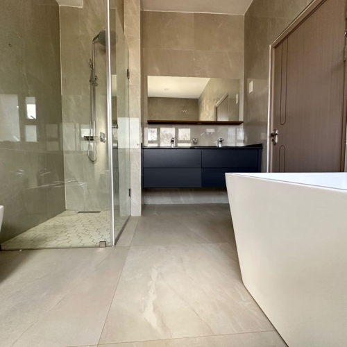 Zimbabwe full house custom bathroom featuring a glass shower, sleek vanity, and elegant tile design.